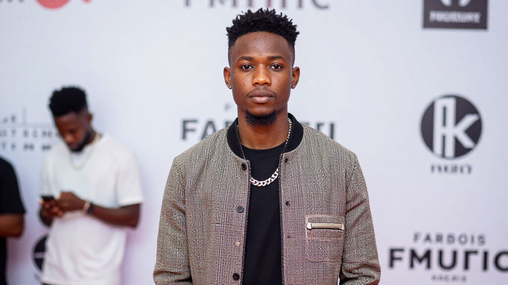 Asake at a music industry event showcasing his distinctive fashion sense